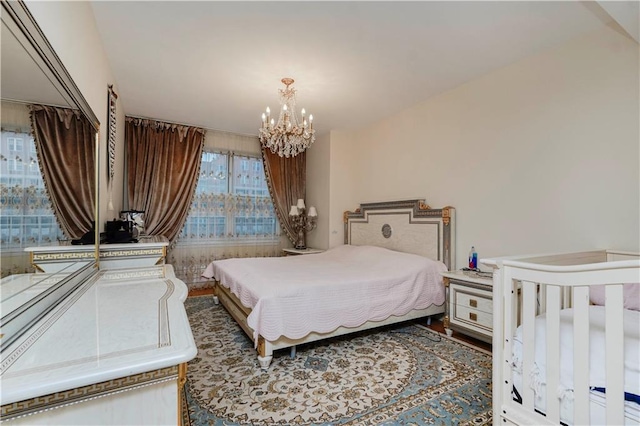 bedroom with an inviting chandelier and wood finished floors