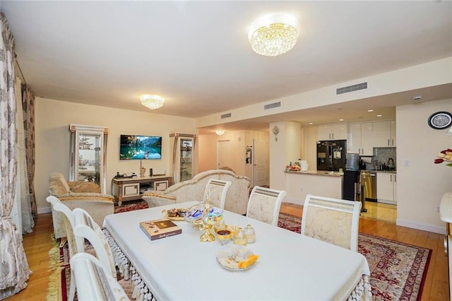 dining space featuring visible vents, baseboards, and light wood-style floors