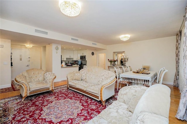 living area with visible vents, baseboards, and light wood-style floors