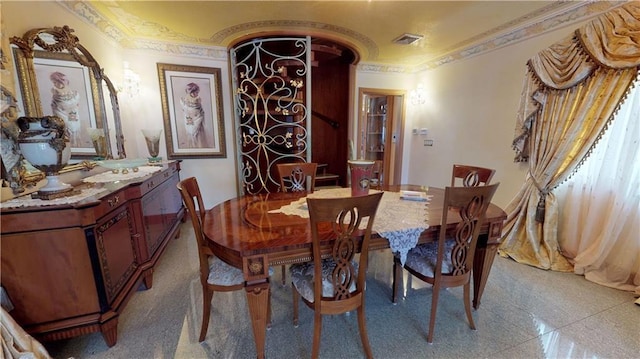 dining area featuring ornamental molding, visible vents, and granite finish floor