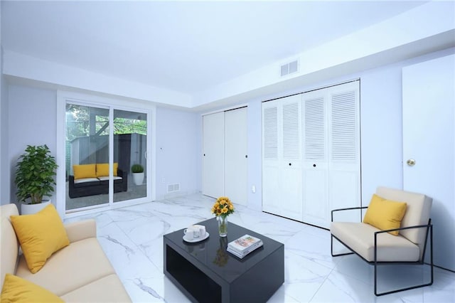 living room featuring marble finish floor and visible vents