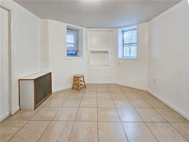 unfurnished room featuring light tile patterned flooring and baseboards