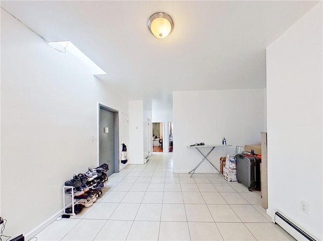 bonus room featuring a baseboard heating unit and light tile patterned flooring