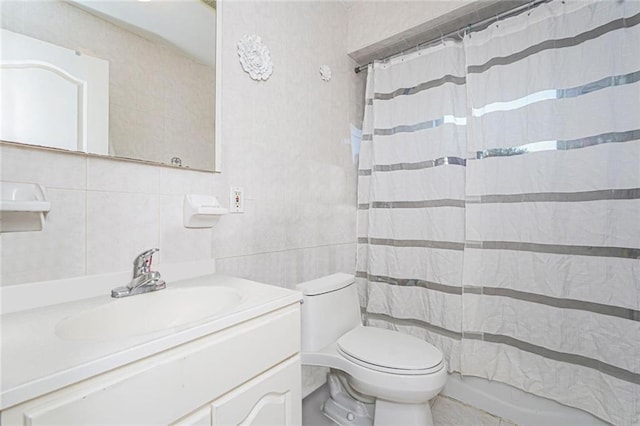 bathroom featuring tasteful backsplash, toilet, curtained shower, vanity, and tile walls