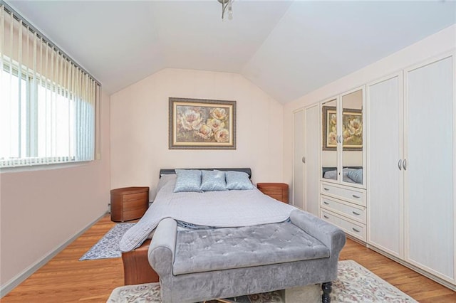 bedroom featuring lofted ceiling and light wood finished floors