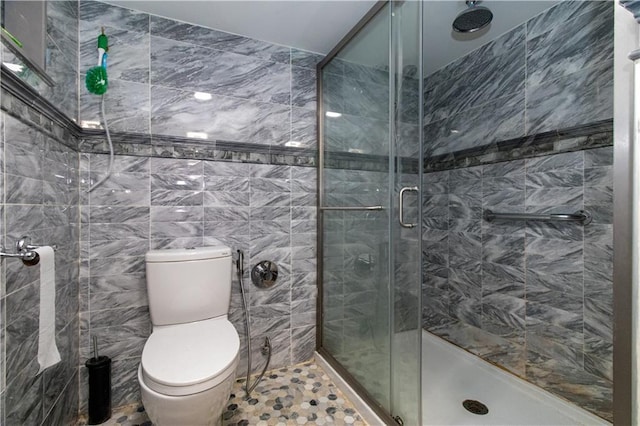 full bath featuring tile walls, a shower stall, and toilet