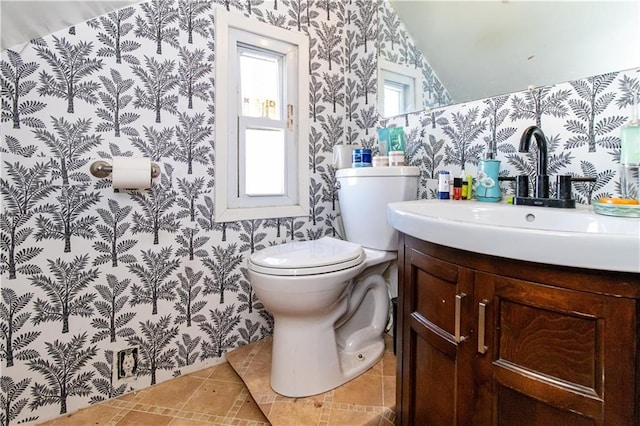 bathroom with toilet, wallpapered walls, tile patterned flooring, and vanity