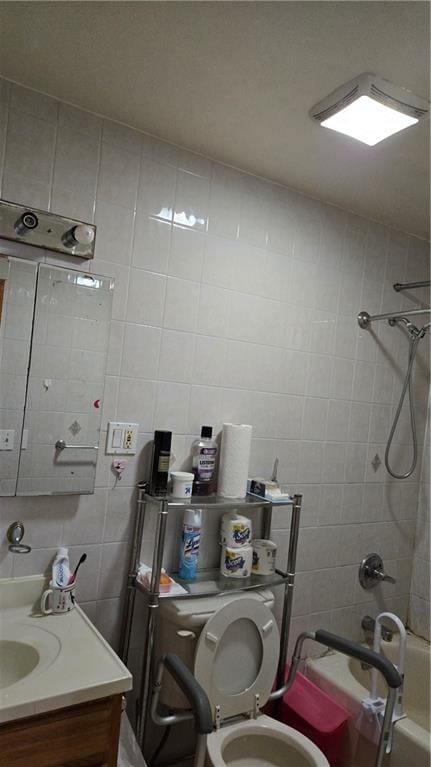 bathroom featuring tile walls, bathing tub / shower combination, tasteful backsplash, toilet, and vanity