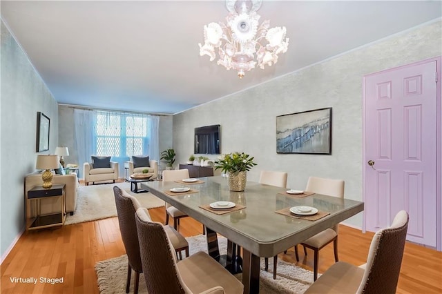 dining area with light wood-style floors and a notable chandelier