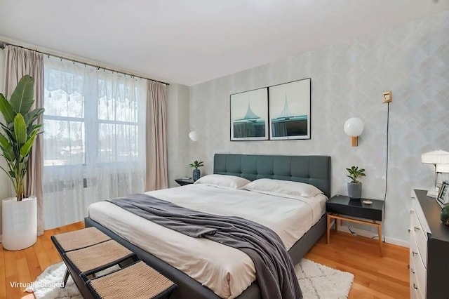 bedroom with light wood-type flooring and baseboards