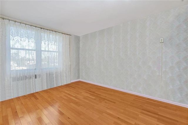 empty room with hardwood / wood-style flooring and baseboards