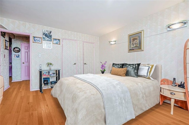 bedroom featuring arched walkways, a closet, and wood finished floors