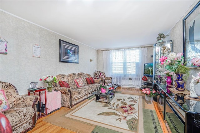 living room with wood finished floors and crown molding