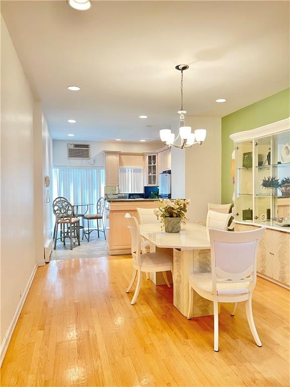 dining room featuring recessed lighting, baseboards, light wood-style floors, an AC wall unit, and an inviting chandelier