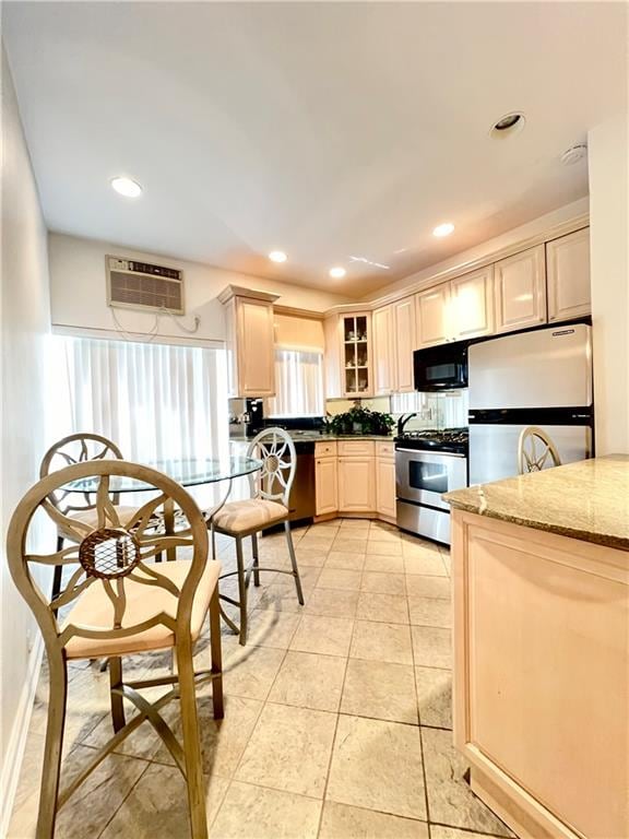 kitchen with dark stone counters, appliances with stainless steel finishes, a wall mounted AC, and recessed lighting