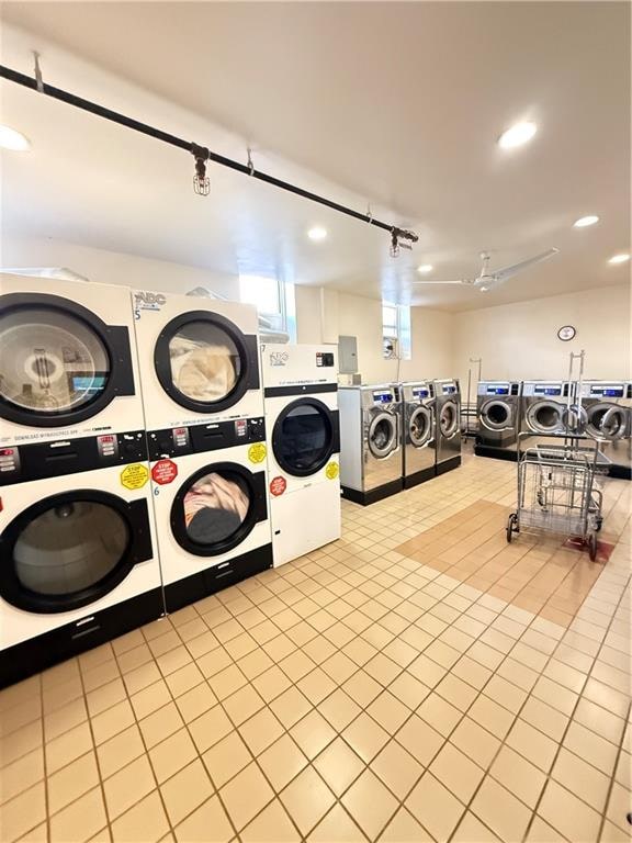 common laundry area with recessed lighting, stacked washing maching and dryer, washing machine and dryer, and tile patterned floors