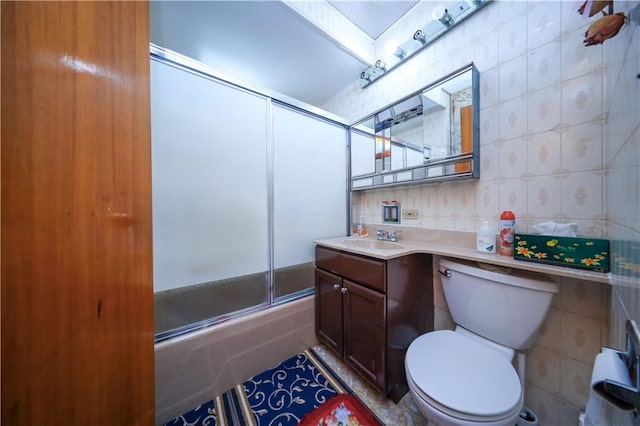 bathroom with combined bath / shower with glass door, vanity, and toilet