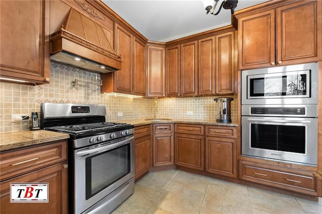 kitchen featuring stainless steel appliances, custom range hood, and brown cabinets