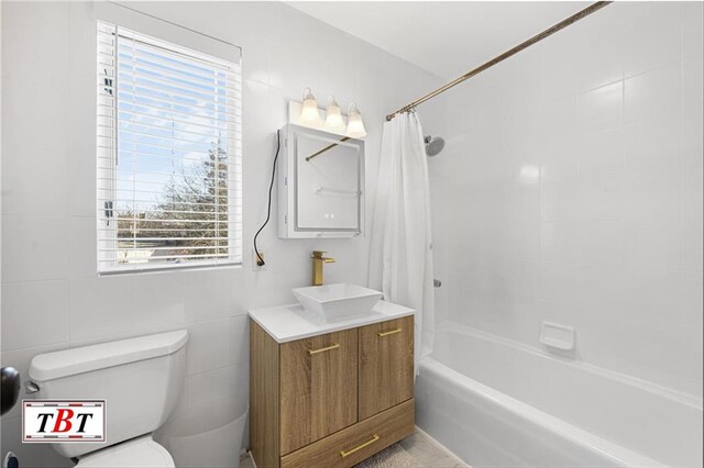 full bath featuring toilet, shower / bath combo with shower curtain, and vanity