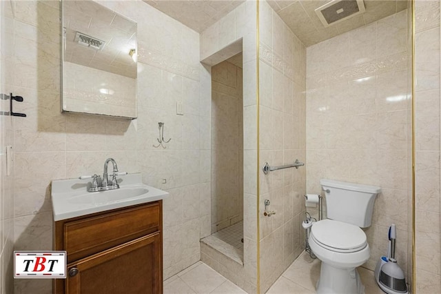 full bath featuring tile walls, tile patterned flooring, a shower stall, vanity, and toilet