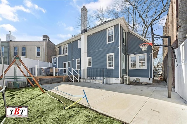 rear view of property featuring a deck, a chimney, a patio, and ac unit