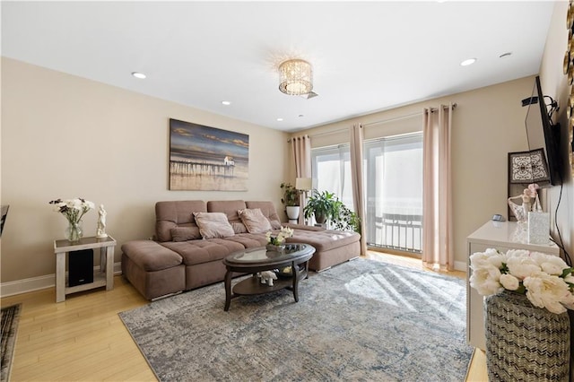 living room featuring recessed lighting, baseboards, and light wood finished floors