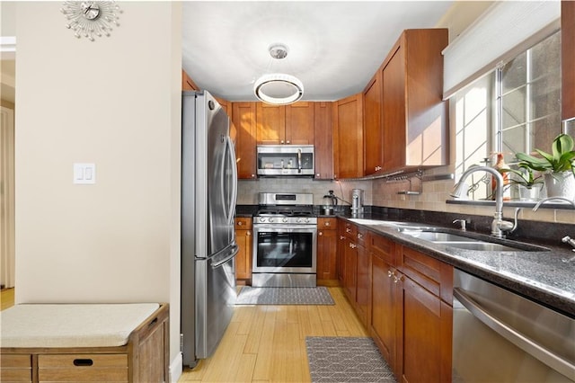 kitchen with tasteful backsplash, appliances with stainless steel finishes, brown cabinets, and a sink