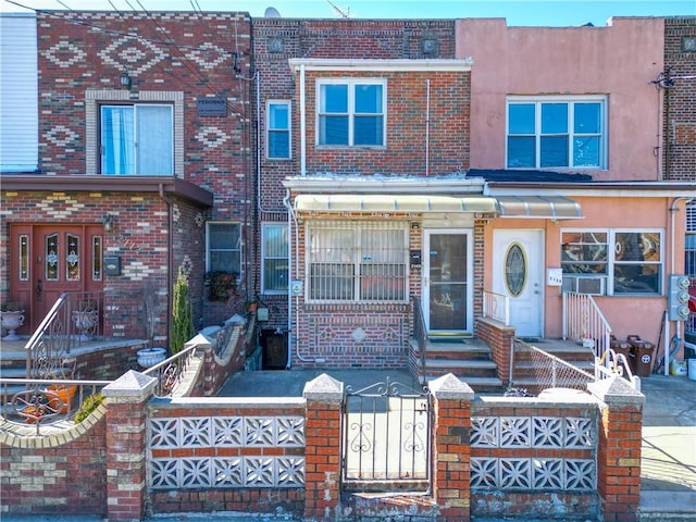 view of property featuring a fenced front yard, stucco siding, and brick siding