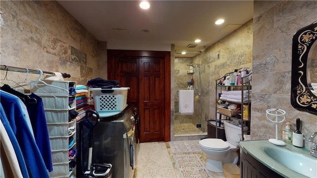 bathroom with washing machine and dryer, tile walls, and tiled shower