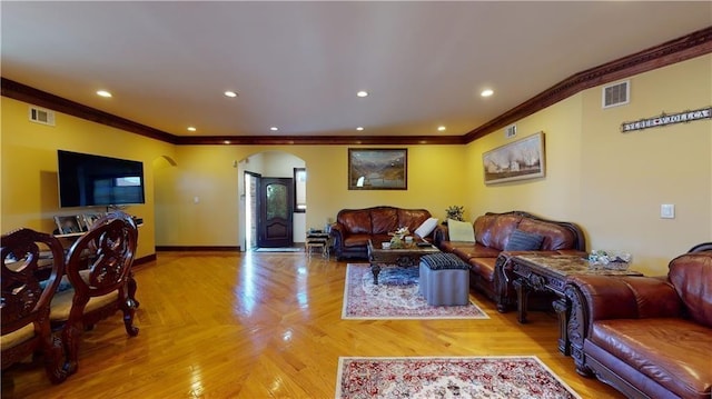 living room featuring visible vents, arched walkways, baseboards, and ornamental molding