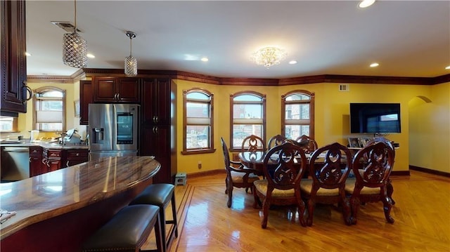 dining space with baseboards, light wood-type flooring, recessed lighting, and crown molding