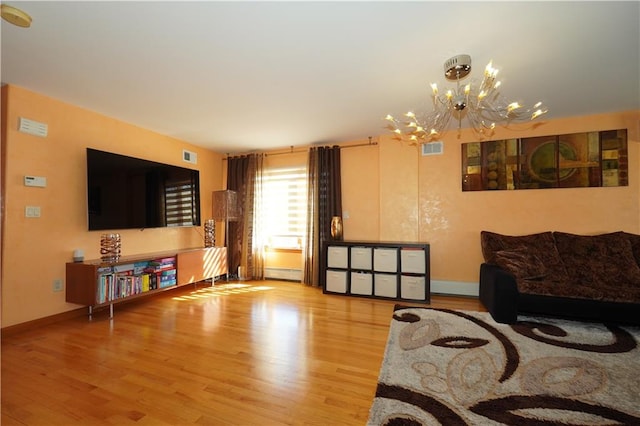 living room featuring baseboards, visible vents, a baseboard heating unit, and wood finished floors