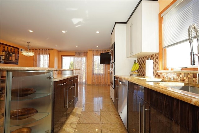 kitchen with dark brown cabinetry, white cabinets, modern cabinets, stainless steel appliances, and backsplash