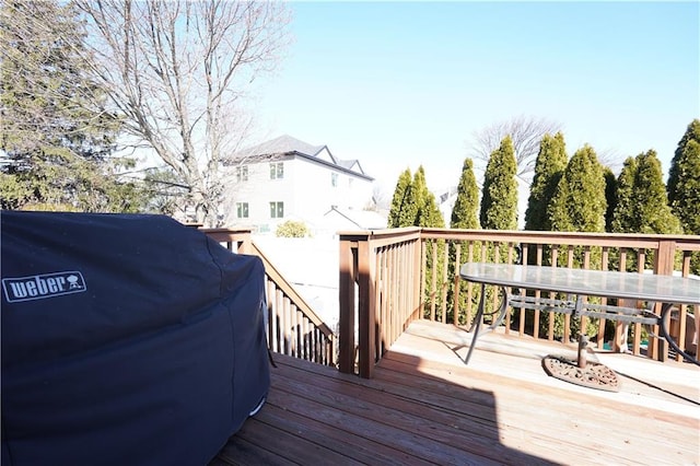 wooden terrace with outdoor dining area and grilling area