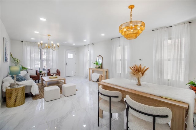 dining area featuring marble finish floor, recessed lighting, and an inviting chandelier