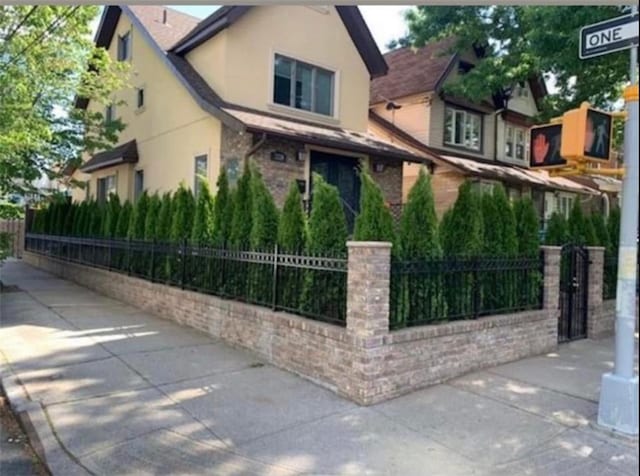 3224 L Ave, Brooklyn, NY 11210 - view of property exterior with a fenced front yard and stucco siding