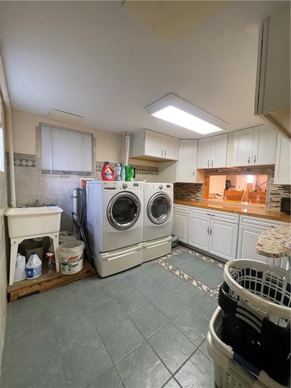 laundry area featuring cabinet space, a wainscoted wall, independent washer and dryer, tile patterned flooring, and tile walls