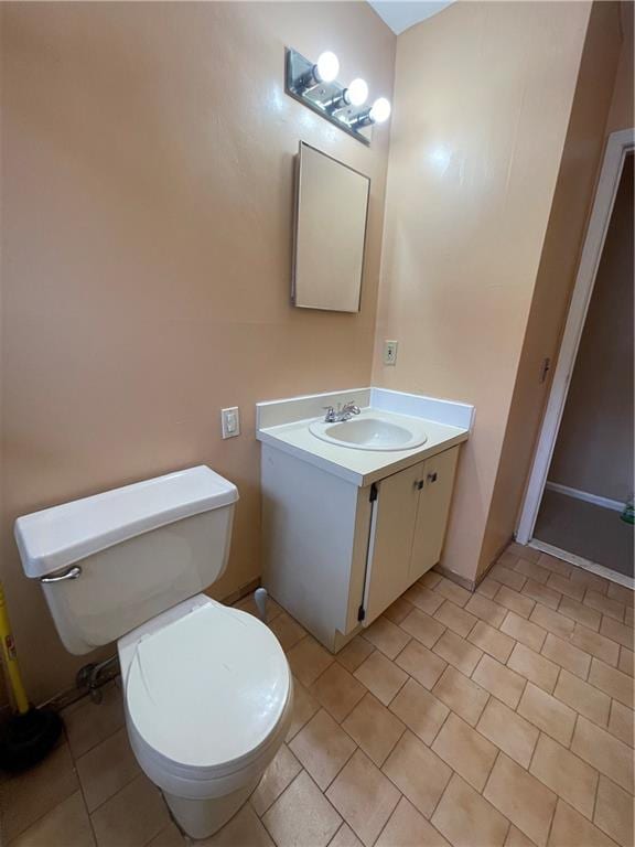 bathroom with tile patterned flooring, vanity, and toilet