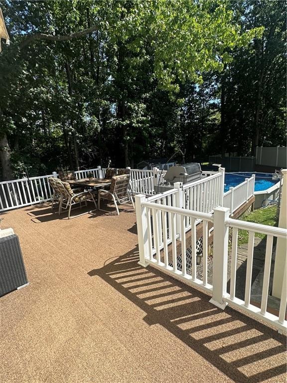 view of patio / terrace featuring outdoor dining space, fence, and an outdoor pool