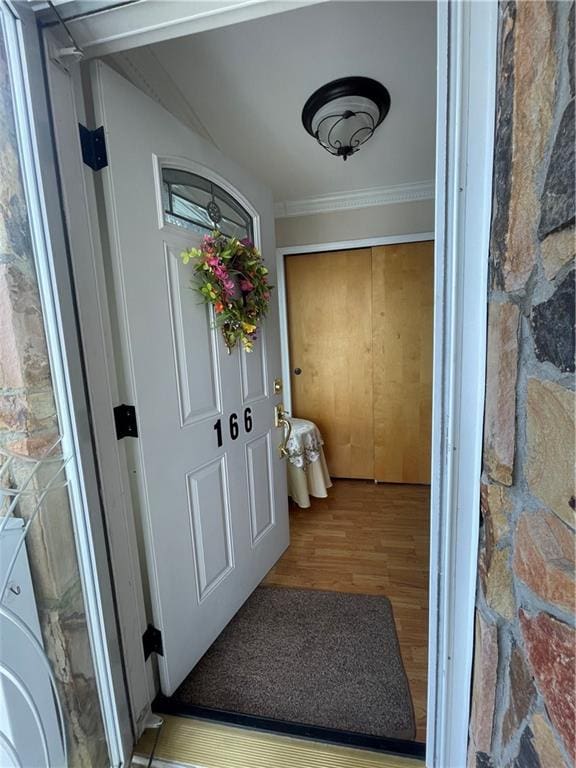 interior space with ornamental molding, washer / clothes dryer, and wood finished floors