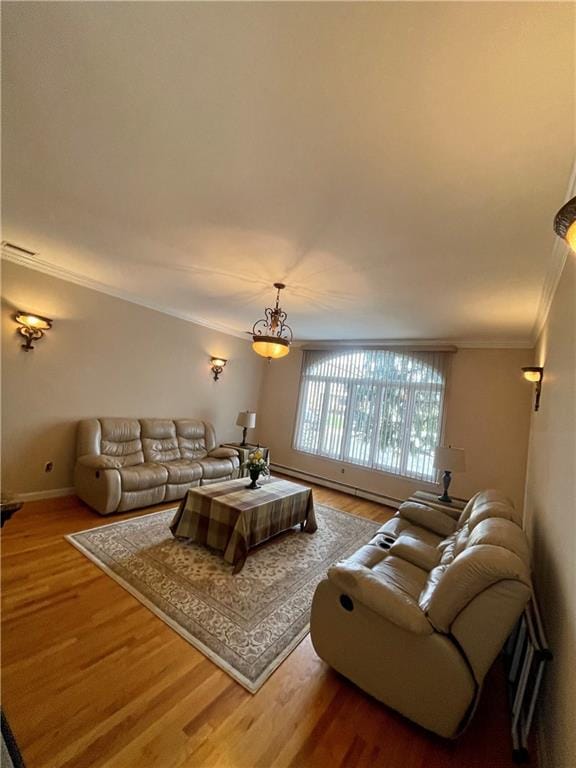 living room featuring visible vents, baseboard heating, ornamental molding, wood finished floors, and baseboards