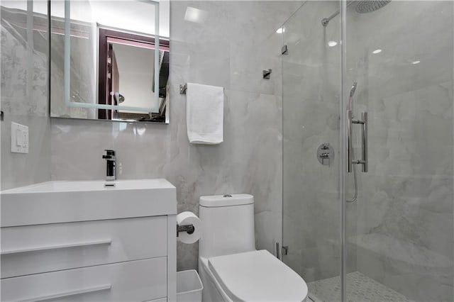 bathroom with vanity, a shower stall, toilet, and decorative backsplash