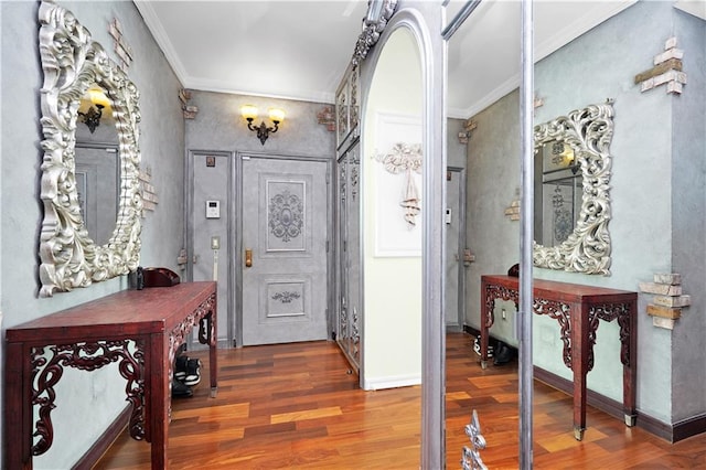 foyer entrance with wood finished floors, baseboards, and ornamental molding