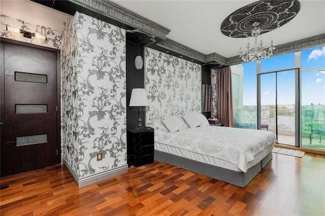 bedroom with access to exterior, wallpapered walls, baseboards, and wood finished floors