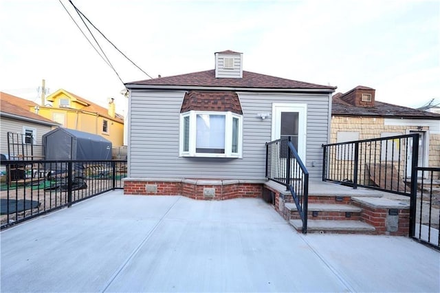 rear view of house featuring crawl space, a patio area, fence, and roof with shingles