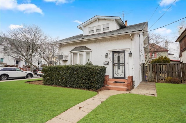 bungalow with fence, a front lawn, a chimney, and stucco siding