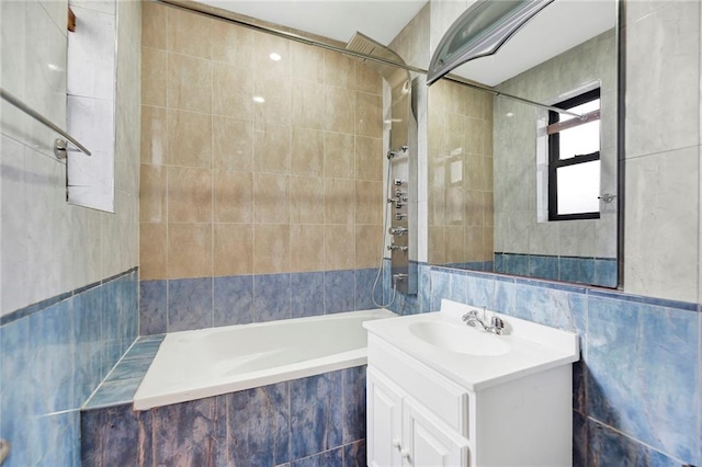 bathroom featuring tiled shower / bath, tile walls, and vanity