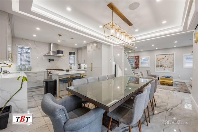 dining area featuring a tray ceiling, marble finish floor, and recessed lighting