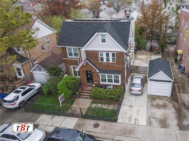 view of front facade featuring a fenced front yard, a residential view, brick siding, and roof with shingles