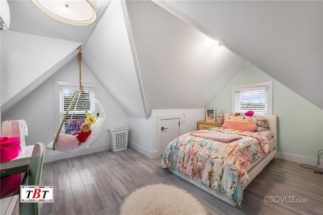 bedroom featuring lofted ceiling, wood finished floors, and baseboards